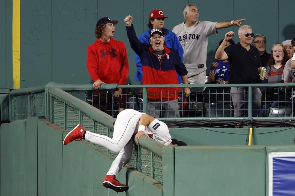 Boston Red Sox's Jarren Duran nearly goes over the bull pen wall while trying to field a solo home run by Toronto Blue Jays' Matt Chapman during the ninth inning of a baseball game, Friday, Aug. 4, 2023, in Boston. (AP Photo/Michael Dwyer)