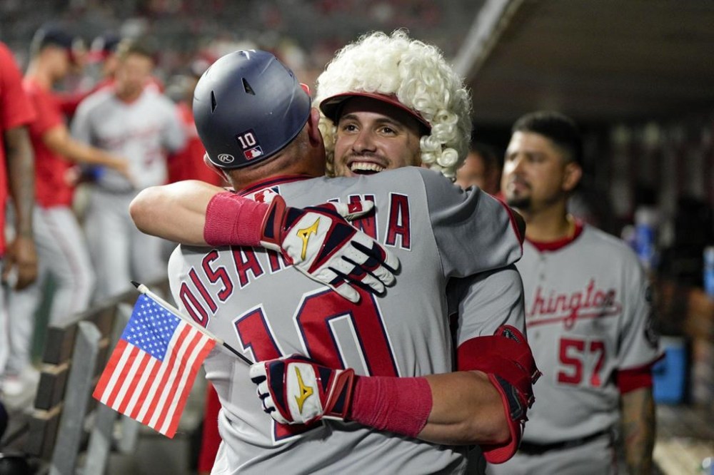 Washington Nationals' Lane Thomas, center right, celebrates with third base coach Gary Disarcina (10) after hitting a two-run home run against the Cincinnati Reds during the 10th inning of a baseball game Friday, Aug. 4, 2023, in Cincinnati. (AP Photo/Jeff Dean)