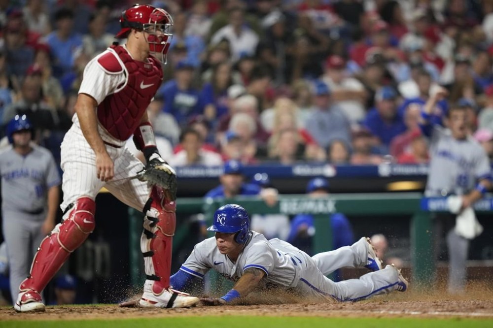 Kansas City Royals' Freddy Fermin, right, scores past Philadelphia Phillies catcher J.T. Realmuto on a two-run single by Dairon Blanco during the sixth inning of a baseball game, Friday, Aug. 4, 2023, in Philadelphia. (AP Photo/Matt Slocum)