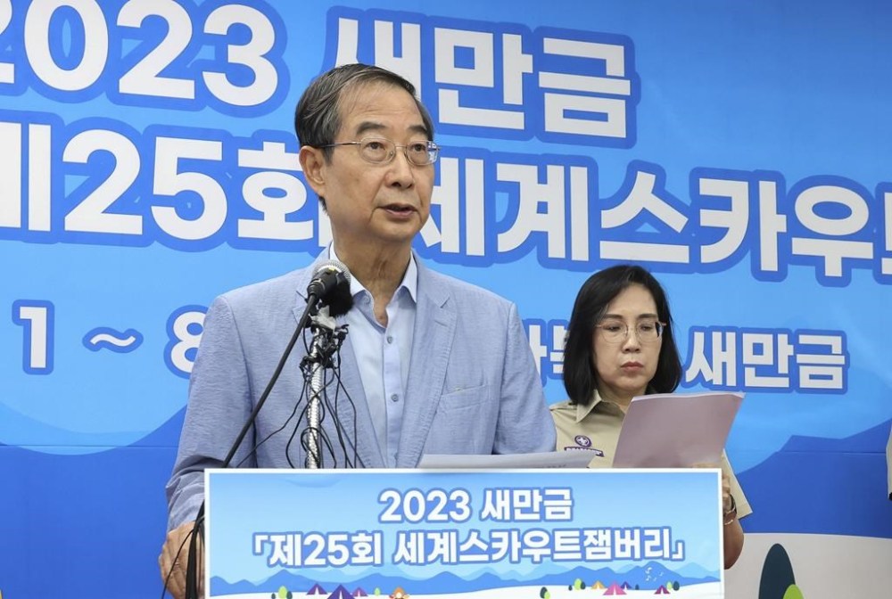 South Korean Prime Minister Han Duck-soo speaks during a press conference at the World Scout Jamboree in Buan, South Korea, Saturday, Aug. 5, 2023. Prime Minister Han said during a In a news conference that the country is determined to continue the event as planned through Aug. 12. He promised additional measures to ensure the safety of participants, including more medical staff, air-conditioned vehicles and structures that provide shade. The letters read