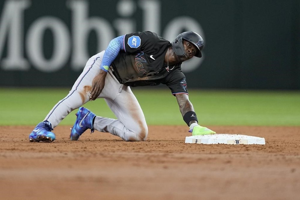 Miami Marlins' Jazz Chisholm Jr. places his hand on his right leg as he looks to the dugout after attempting to steal second base in the third inning of a baseball game against the Texas Rangers, Saturday, Aug. 5, 2023, in Arlington, Texas. Chisholm left the game with an unknown injury. (AP Photo/Tony Gutierrez)