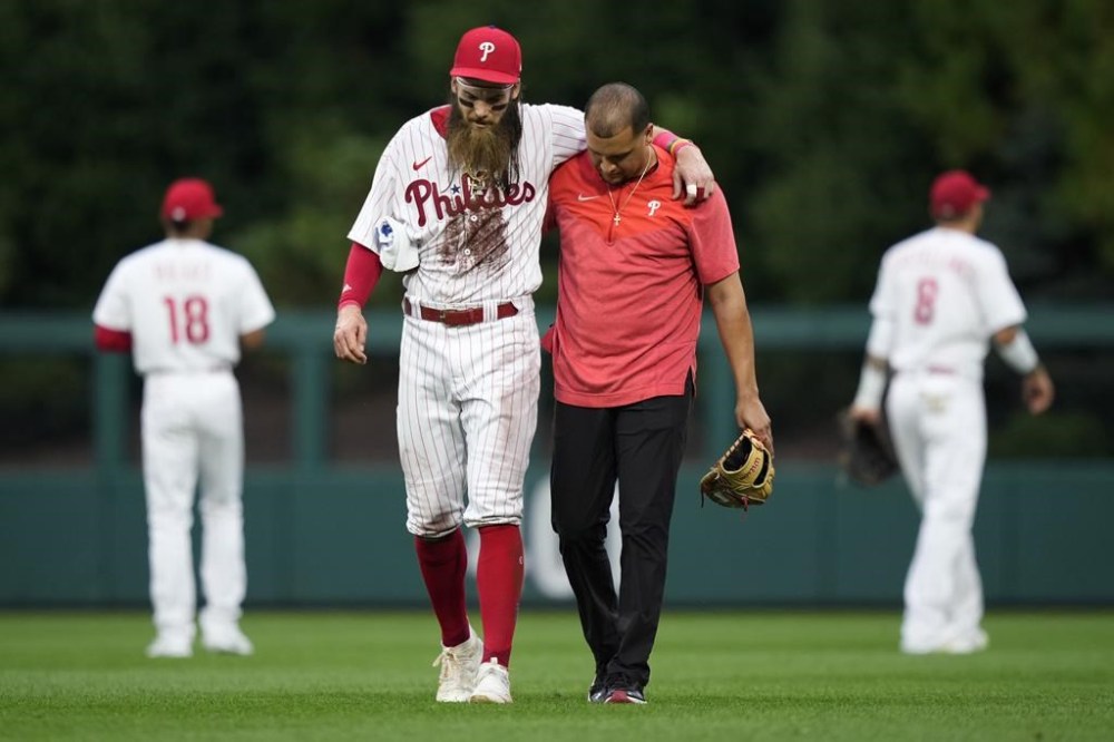Philadelphia Phillies' Brandon Marsh is helped off the field after an injury during the fifth inning of a baseball game against the Kansas City Royals, Saturday, Aug. 5, 2023, in Philadelphia. (AP Photo/Matt Slocum)