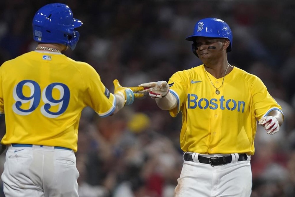 Boston Red Sox's Alex Verdugo (99) celebrates with Rafael Devers, right, as Devers returns to the dugout after hitting a home run in the sixth inning of a baseball game against the Atlanta Braves, Wednesday, July 26, 2023, in Boston. (AP Photo/Steven Senne)
