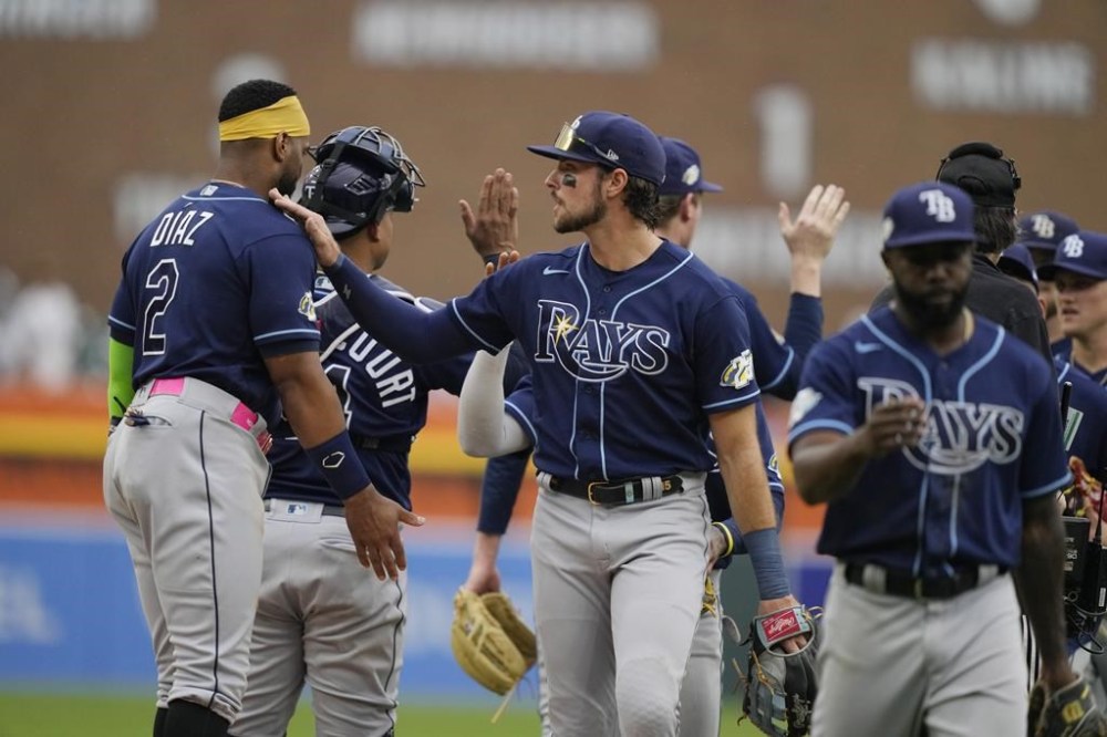 Tampa Bay Rays center fielder Josh Lowe, center, and left fielder Randy Arozarena, right, greet teammates after the ninth inning of a baseball game against the Detroit Tigers, Sunday, Aug. 6, 2023, in Detroit. (AP Photo/Carlos Osorio)