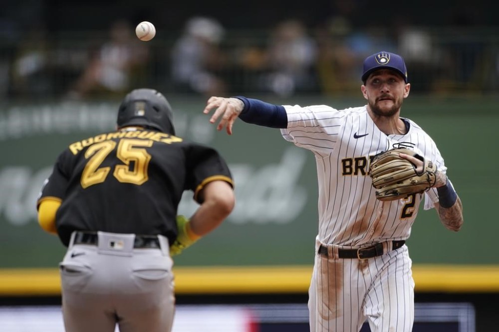 Milwaukee Brewers' Brice Turang (2) throws to first base after tagging out Pittsburgh Pirates' Endy Rodriguez (25) at second base to turn a double play during the fifth inning of a baseball game Sunday, Aug. 6, 2023, in Milwaukee. (AP Photo/Aaron Gash)