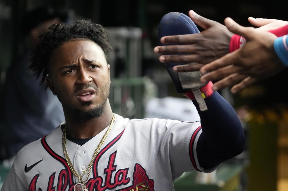 Atlanta Braves' Ozzie Albies celebrates with teammates after scoring on a one-run single by Matt Olson during the fifth inning of a baseball game against the Chicago Cubs in Chicago, Sunday, Aug. 6, 2023. (AP Photo/Nam Y. Huh)