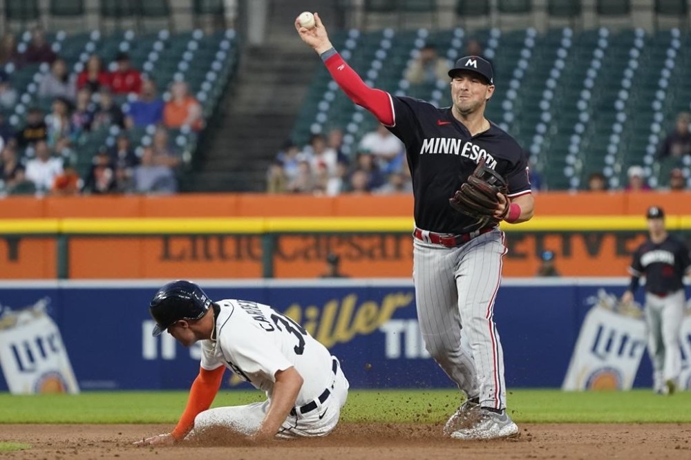 Minnesota Twins second baseman Kyle Farmer forces out Detroit Tigers' Kerry Carpenter after Zach McKinstry hit into a fielder's choice during the seventh inning of a baseball game, Monday, Aug. 7, 2023, in Detroit. (AP Photo/Carlos Osorio)