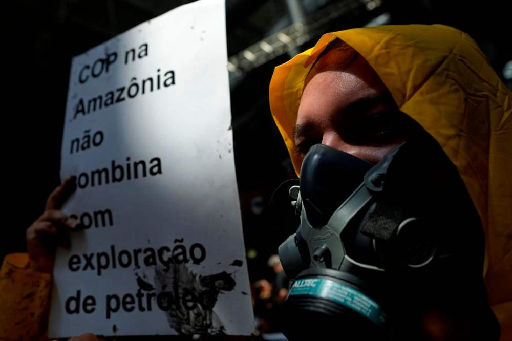 ADDS FRENCH GUIANA - An activist with a gas mask holds a sign that reads in Portuguese