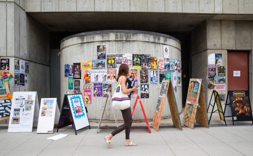 JESSICA LEE / WINNIPEG FREE PRESS
A pedestrian reads posters for the Fringe Festival in the Exchange District.