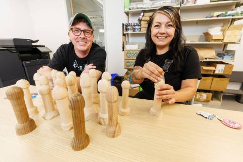 MIKE DEAL / WINNIPEG FREE PRESS 
                                Jason Hooper, left, with 20 different Woodies he&rsquo;s made for Gillian Roy and the Sexual Education Resource Centre.