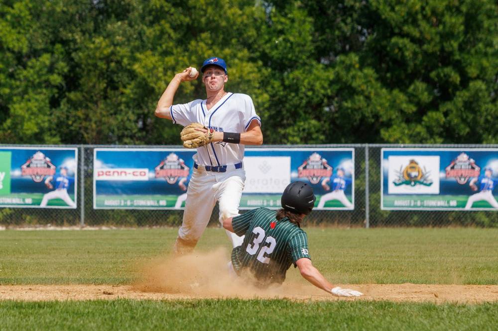 MIKE DEAL / WINNIPEG FREE PRESS
                                Manitoba’s Chris Fines throws the ball to first base to attempt a double-play after taking care of P.E.I.’s Tanner MacLean at second Thursday at Fines Field in Stonewall Quarry Park on the opening day of the U22 men’s baseball national championships.