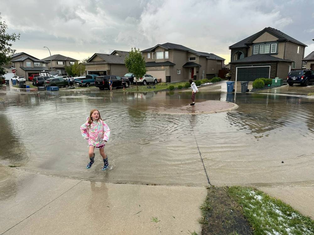 KAREN SCARSBROOK PHOTO
Children play in an east Transcona street after a hailstorm Thursday night.