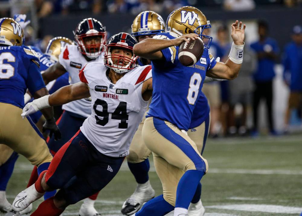 Winnipeg Blue Bombers quarterback Zach Collaros (8) is sacked by Montreal Alouettes’ Mustafa Johnson (94) during first half CFL action in Winnipeg Aug. 24. (John Woods / The Canadian Press files)