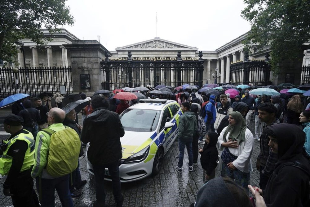 Police and bystanders stand outside the British Museum after an incident close to the museum, in London, Tuesday, Aug. 8, 2023. Police in London say they have arrested a man suspected of stabbing another man near the British Museum. The museum known for housing the Rosetta Stone was evacuated Tuesday but police say there's no more risk to the public. Metropolitan Police said the stabbing occurred at a street corner near the museum's entrance. (Jordan Pettitt/PA via AP)