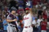 Philadelphia Phillies' Bryce Harper, right, reacts past Washington Nationals catcher Riley Adams after hitting a two-run home run during the fifth inning of the second baseball game in a doubleheader, Tuesday, Aug. 8, 2023, in Philadelphia. (AP Photo/Matt Slocum)