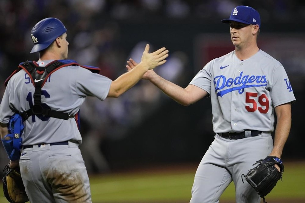 Los Angeles Dodgers' relief pitcher Evan Phillips, right, greets catcher Will Smith after a baseball game against the Arizona Diamondbacks, Wednesday, Aug. 9, 2023, in Phoenix. The Dodgers defeated the Diamondbacks 2-0. (AP Photo/Matt York)