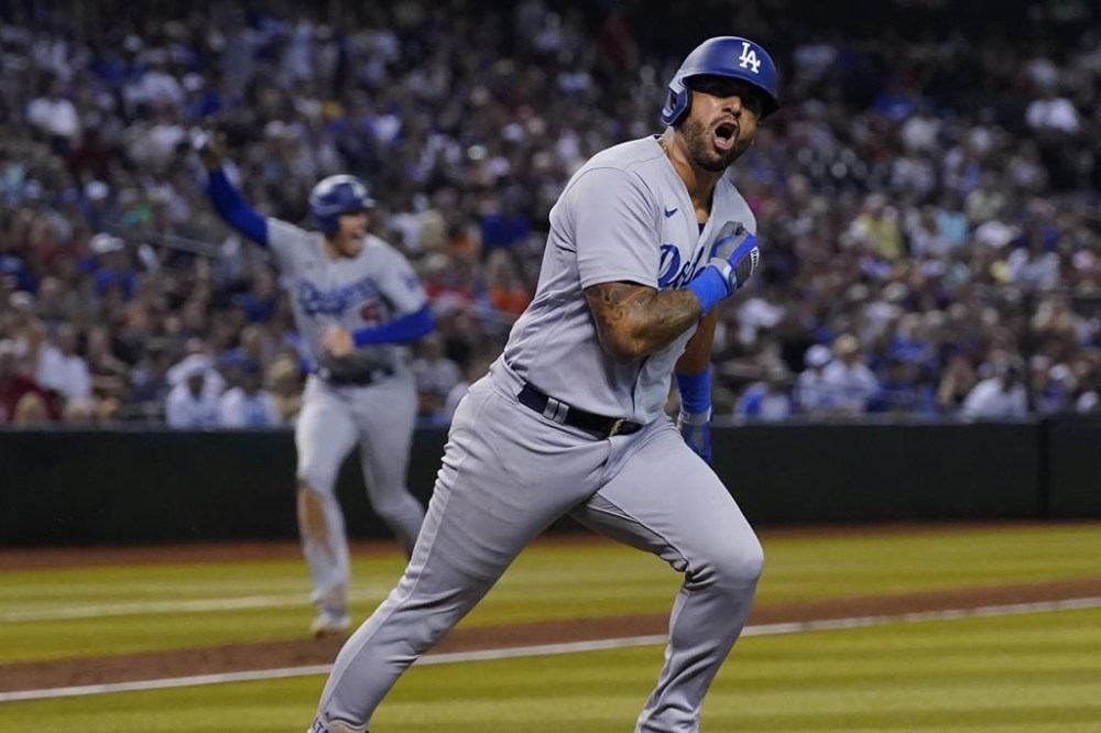 Los Angeles Dodgers' David Peralta yells towards his dugout as he runs out his two RBI single against the Arizona Diamondbacks during the eighth inning of a baseball game, Wednesday, Aug. 9, 2023, in Phoenix. (AP Photo/Matt York)
