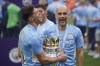 FILE - Manchester City's head coach Pep Guardiola, right, smiles with trophy after winning the 2022 English Premier League title at the Etihad Stadium in Manchester, England, on May 22, 2022. (AP Photo/Dave Thompson, File)