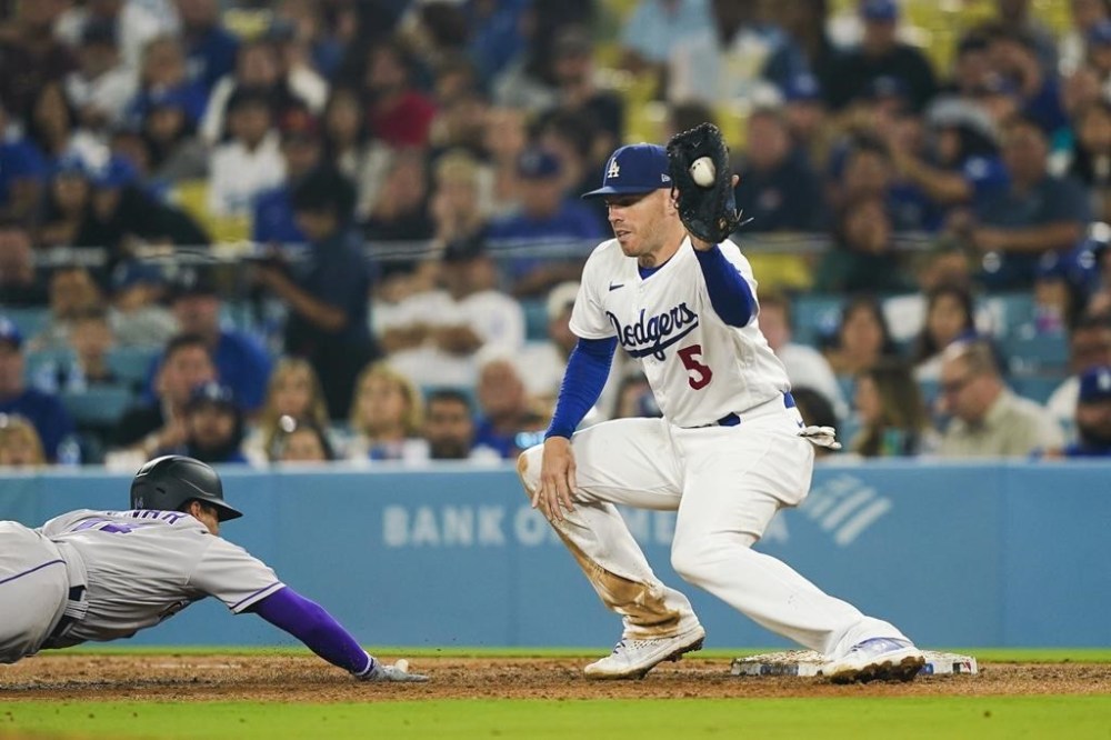 Los Angeles Dodgers first baseman Freddie Freeman (5) attempts to pick off Colorado Rockies' Ezequiel Tovar stealing second base during the sixth inning of a baseball game, Thursday, Aug. 10, 2023, in Los Angeles. (AP Photo/Ryan Sun)