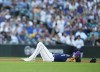 Seattle Mariners shortstop J.P. Crawford lies on the ground after colliding with third baseman Eugenio Suarez as Suarez fielded a grounder by San Diego Padres' Xander Bogaerts, who was out at first during the fourth inning of a baseball game Wednesday, Aug. 9, 2023, in Seattle. (AP Photo/Lindsey Wasson)