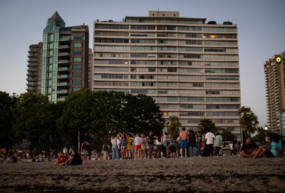 People dance and gather at English Bay Beach during a heat wave, in Vancouver, B.C., on Monday, June 21, 2021. Advocates for renters in British Columbia say it's time to consider setting a maximum temperature for rental housing, to protect already vulnerable tenants from increasingly rising heat. THE CANADIAN PRESS/Darryl Dyck