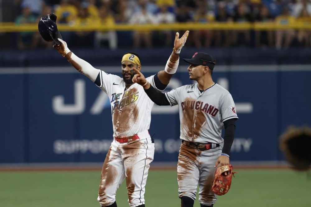 Tampa Bay Rays' Yandy Diaz reacts next to Cleveland Guardians second baseman Andres Gimenez after hitting an RBI double during the third inning of a baseball game Friday, Aug. 11, 2023, in St. Petersburg, Fla. (AP Photo/Scott Audette)