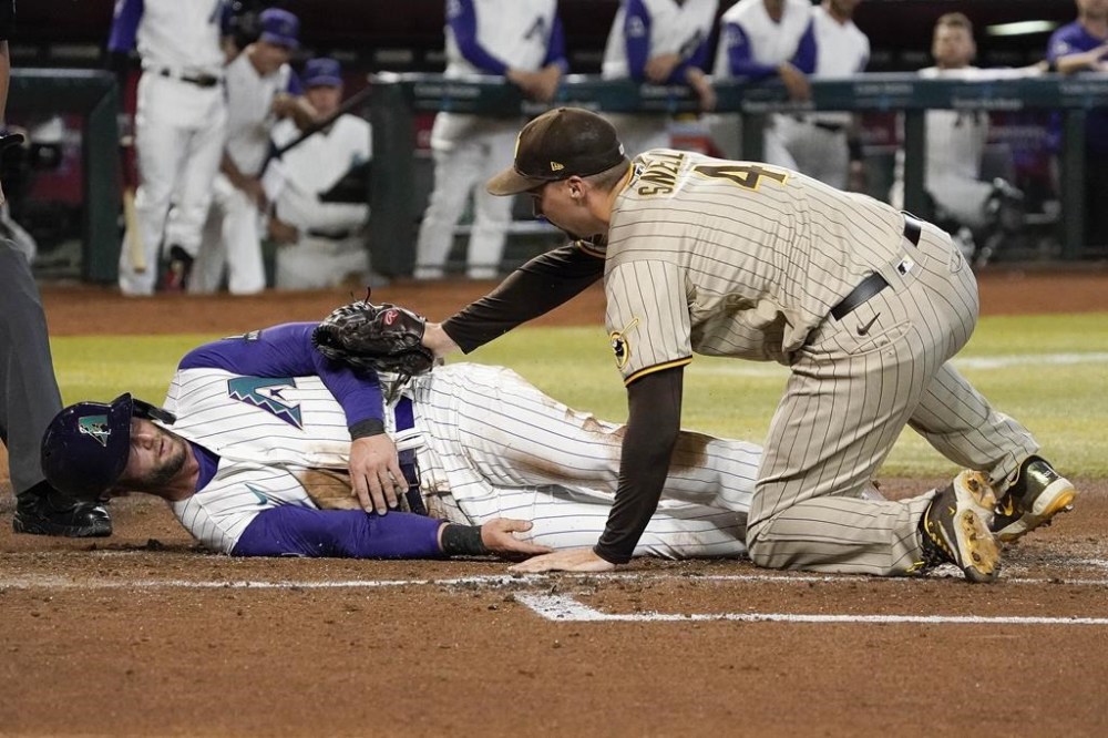San Diego Padres pitcher Blake Snell tags out Arizona Diamondbacks' Christian Walker at home after a passed ball during the first inning of a baseball game Friday, Aug. 11, 2023, in Phoenix. (AP Photo/Darryl Webb)