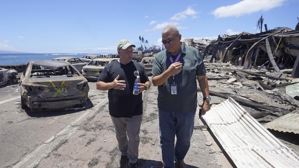 Hawaii Gov. Josh Green, left, and Maui County Mayor Richard Bissen, Jr., speak during a tour of wildfire damage on Saturday, Aug. 12, 2023, in Lahaina, Hawaii. (AP Photo/Rick Bowmer)