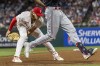 Minnesota Twins' Michael A. Taylor, right, is out at first after Philadelphia Phillies first baseman Alec Bohm made a tag during the seventh inning of a baseball game, Saturday, Aug. 12, 2023, in Philadelphia. (AP Photo/Laurence Kesterson)