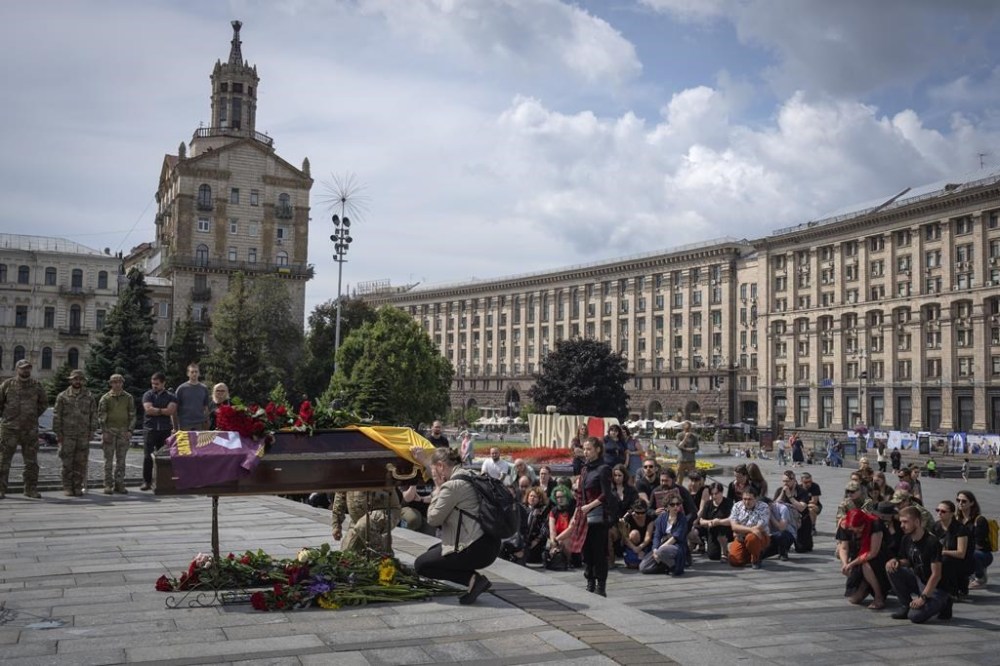 People pay their last respects at a coffin of woman military medic Dariya Filipova, killed in a battle with the Russian troops, during a farewell ceremony in Independence Square in Kyiv, Ukraine, Saturday, Aug. 12, 2023. (AP Photo/Efrem Lukatsky