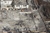 Emergency personnel conduct searches in properties destroyed by wildfires in Lahaina, Hawaii Friday, Aug. 11, 2023. (Stephan Lam/San Francisco Chronicle via AP)