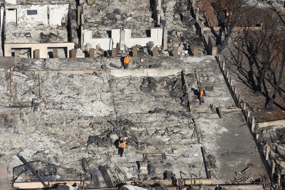 Emergency personnel conduct searches in properties destroyed by wildfires in Lahaina, Hawaii Friday, Aug. 11, 2023. (Stephan Lam/San Francisco Chronicle via AP)