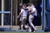 Colorado Rockies left fielder Jurickson Profar is helped off the field after colliding with the wall while making a catch on a ball hit by Los Angeles Dodgers' Mookie Betts during the second inning of a baseball game Sunday, Aug. 13, 2023, in Los Angeles. (AP Photo/Mark J. Terrill)