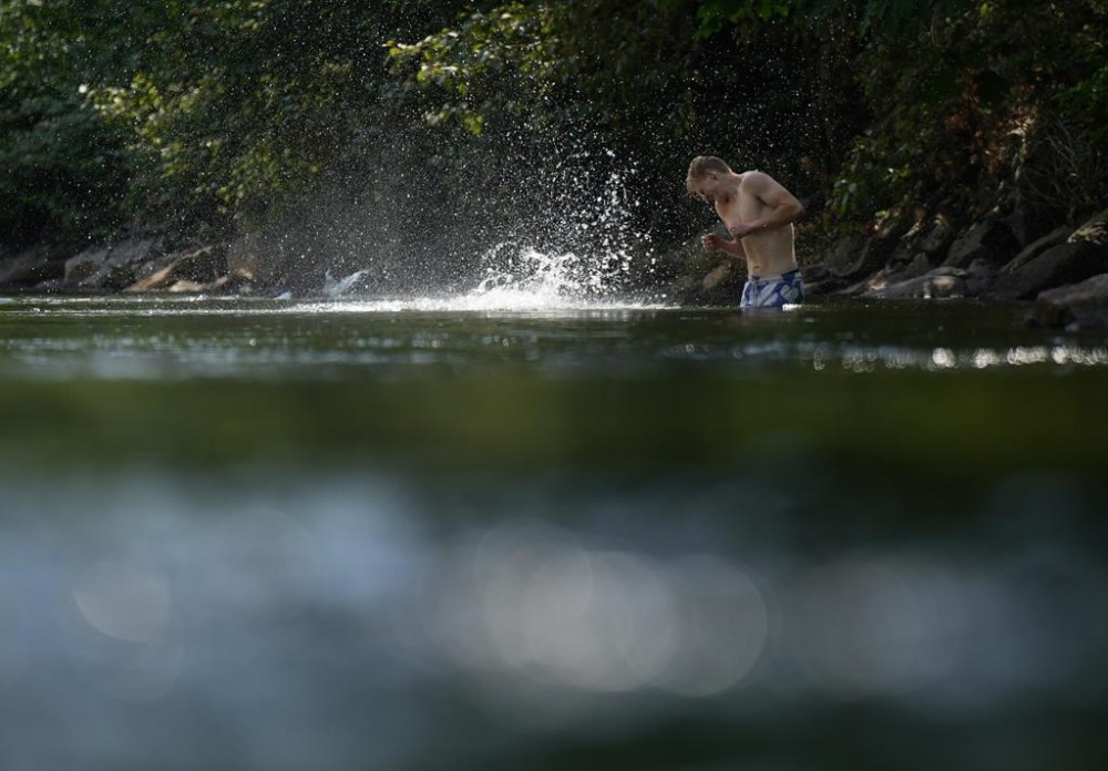 A person cools off in Lynn Creek in North Vancouver, B.C., on Thursday, July 6, 2023. Health authorities as well as local and provincial governments across British Columbia are providing guidance on how best to deal with a sweltering heat wave that began in British Columbia's southern coast this weekend is expected to expand into the Interior starting today.THE CANADIAN PRESS/Darryl Dyck