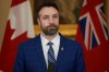 Andrew Smith speaks to the media at a press conference after he wad sworn in at the Manitoba Legislative Building in Winnipeg on Tuesday Jan. 18, 2022. He says people who are upset they can't buy alcohol due to a strike by staff at Crown-owned liquor stores should blame 