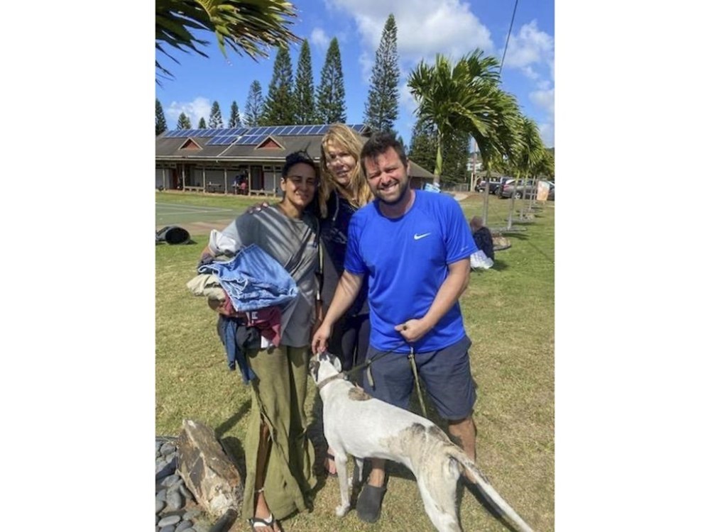 This Aug. 9, 2023 photo taken by his stepfather Mike Eilers and provided by Mike Cicchino shows Mike Cicchino holding his dog Raina, right, his wife Andreza Cicchino, left and his mother Susan Ramos pose for a picture as they were reunited at shelter in Maui, Hawaii. (Courtesy of Mike Cicchino via AP)