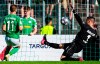 Homburg's Markus Mendler, left, scores his team's first goal against Darmstadt's goalkeeper Marcel Schuhen during the first round of the German Cup at the Waldstadion, in Homburg, Germany, Monday, Aug. 14, 2023. (Tom Weller/dpa via AP)