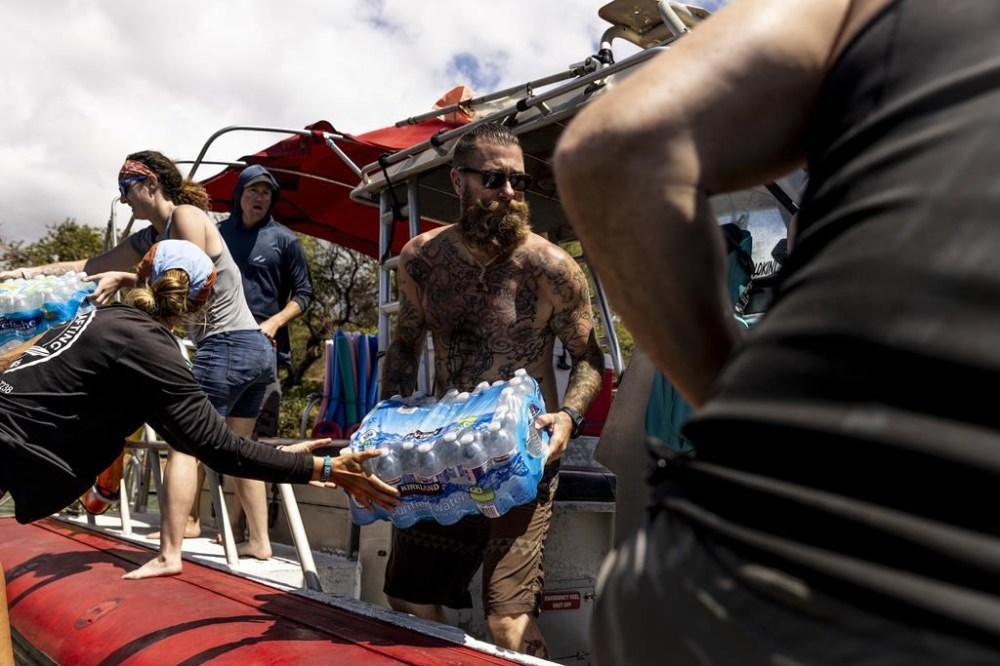 Volunteers load supplies onto a boat for West Maui at the Kihei boat landing, after a wildfire destroyed much of the historical town of Lahaina, on the island of Maui, Hawaii Sunday, Aug. 13, 2023. (Stephen Lam/San Francisco Chronicle via AP)