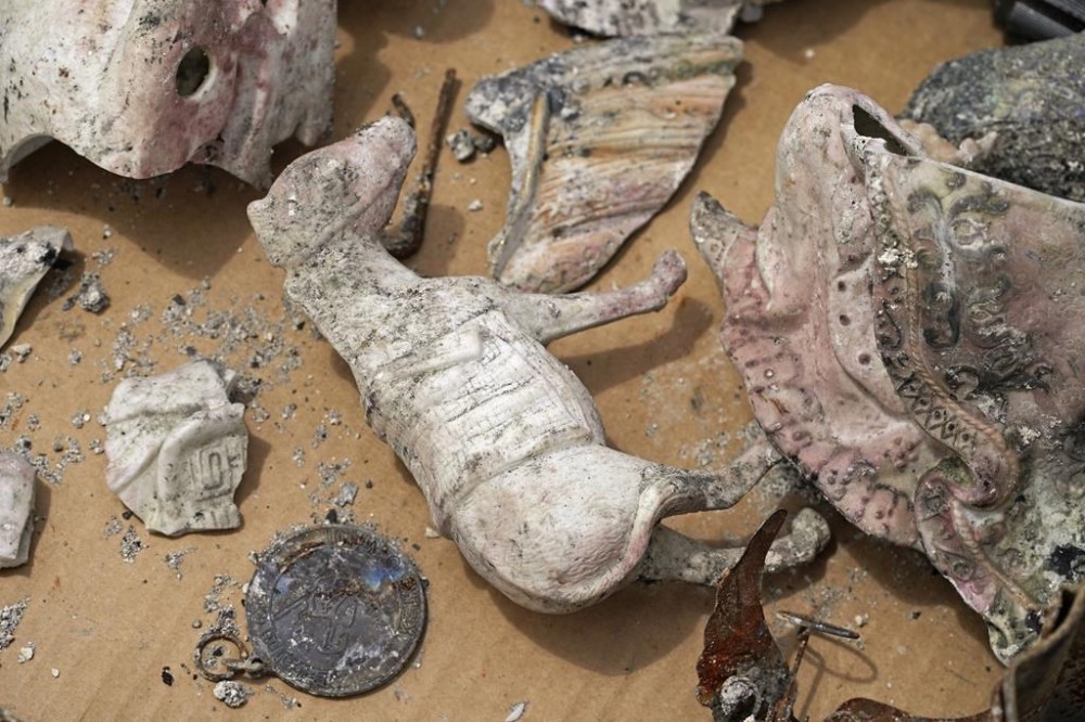Several keepsakes are collected in a box a home destroyed by a wildfire on Monday, Aug. 14, 2023, in Kula, Hawaii. Kula was ravaged by a wildfire the same day one ripped through Lahaina. (AP Photo/Rick Bowmer)