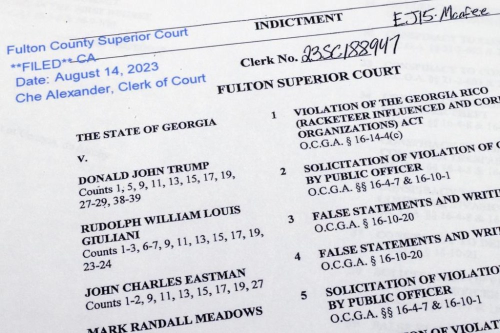 The indictment in Georgia against former President Donald Trump is photographed Monday, Aug. 14, 2023. Trump and several allies have been indicted in Georgia over efforts to overturn his 2020 election loss in the state. The criminal case announced Monday is the fourth brought against the ex-president in a matter of months. (AP Photo/Jon Elswick)