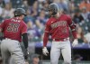 Arizona Diamondbacks' Tommy Pham, left, congratulates Christian Walker as he crosses home plate after hitting a two-run home run off of Colorado Rockies starting pitcher Ty Blach in the third inning of a baseball game Tuesday, Aug. 15, 2023, in Denver. (AP Photo/David Zalubowski)