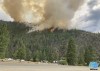 In this photo provided by Caltrans, smoke rises from the Head Fire in Klamath National Forest, Calif., on Tuesday Aug. 15, 2023. A wildfire pushed by gusty winds from a thunderstorm raced through national forest land near California's border with Oregon, prompting evacuations in the rural area. The blaze in Siskiyou County was one of at least 19 fires that erupted in the Klamath National Forest as thunderstorms rolling through the area brought lightning and downdrafts that drove the flames through timber and rural lands. (Roger Matthews/Catrans via AP)