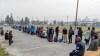 People without vehicles lineup to register for a flight to Calgary in Yellowknife on Thursday, August 17, 2023. Communities receiving evacuees from the Northwest Territories fleeing wildfires have sprung into action to lend a helping hand. THE CANADIAN PRESS/Bill Braden