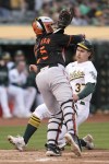 Oakland Athletics' Tyler Soderstrom, right, slides home to score against Baltimore Orioles catcher Adley Rutschman, left, during the second inning of a baseball game in Oakland, Calif., Friday, Aug. 18, 2023. (AP Photo/Jeff Chiu)