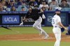 Miami Marlins' Jake Burger, left, heads to first for a a three-run home run as Los Angeles Dodgers starting pitcher Tony Gonsolin watches during the third inning of a baseball game Friday, Aug. 18, 2023, in Los Angeles. (AP Photo/Mark J. Terrill)
