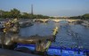 FILE - Athletes dive and swim in the Seine river from the Alexander III bridge on the first leg of the women's triathlon test event for the Paris 2024 Olympics Games in Paris, Thursday, Aug. 17, 2023. In 2024. Paris Olympics organizers and other officials cancelled paratriathlon swimming competition Saturday, Aug. 19, 2023, in the Seine River because of new concerns about water quality. The competition is a key test event ahead of the 2024 Summer Games. (AP Photo/Michel Euler, File)