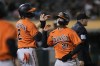 Baltimore Orioles' Gunnar Henderson and Austin Hays (21) greet each other after scoring against the Oakland Athletics during the 10th inning of a baseball game in Oakland, Calif., Saturday, Aug. 19, 2023. (AP Photo/Eric Risberg)