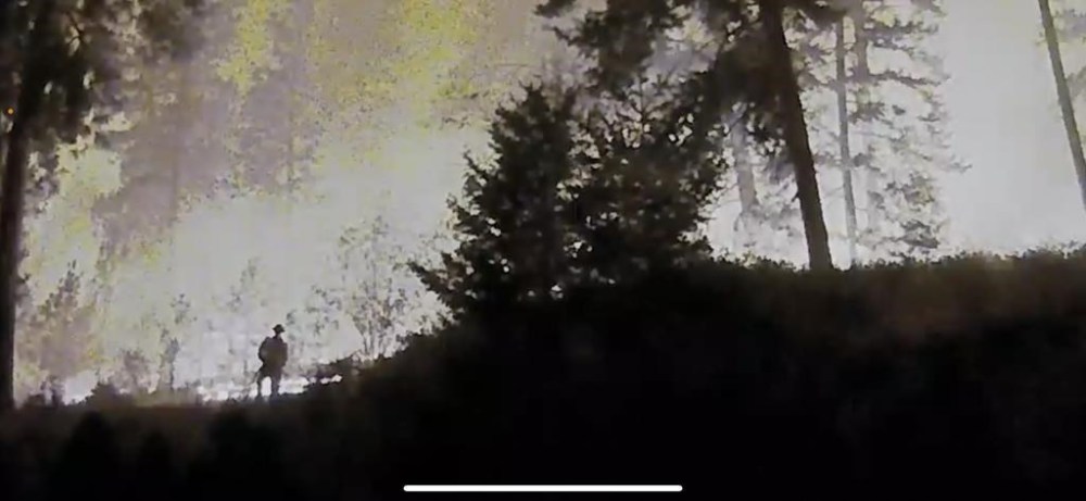 A West Kelowna resident feels so thankful after watching a solo firefighter saving her home from flames with a garden hose from her home's security camera and she spent all night watching this heroic efforts. A lone firefighter, left obscured, is seen fighting flames at a residence in West Kelowna, B.C., in an undated still image taken from residential security camera footage. THE CANADIAN PRESS/HO-Marnie Endersby, *MANDATORY CREDIT*