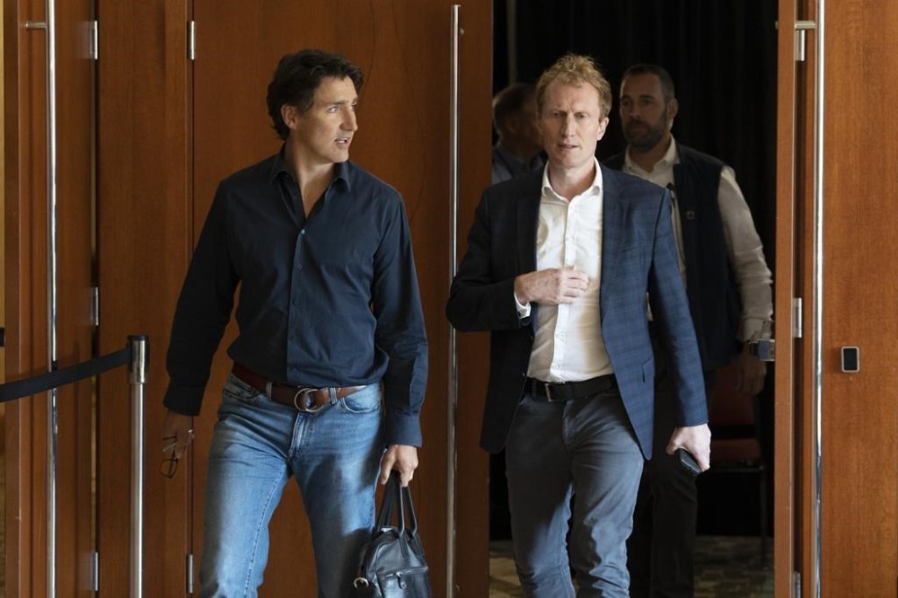 Prime Minister Justin Trudeau, left, and Minister of Immigration, Refugees and Citizenship Marc Miller leave a meeting during the Liberal Cabinet retreat in Charlottetown, Tuesday, Aug. 22, 2023. THE CANADIAN PRESS/Darren Calabrese
