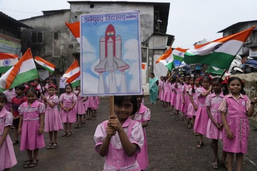 Children wave Indian flags at their school premises in Mumbai, India as they cheer for the successful landing of India’s moon craft Chandrayaan-3, on the moon surface, Tuesday, Aug.22, 2023. India’s previous attempt to land a robotic spacecraft near the moon’s little-explored south pole ended in failure in 2019. (AP Photo/ Rajanish Kakade)